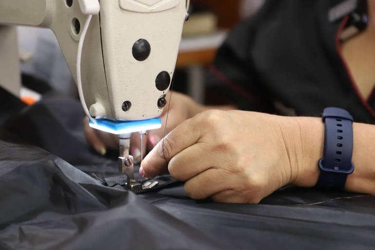 Mujer reparadora utilizando su máquina de coser